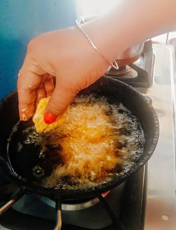 Meanwhile, heat oil in a deep frying pan over medium flame. When the oil is medium hot, slide the vadas one by one into oil from the side of the pan and deep fry them until golden brown and crisp.